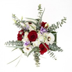 This bouquet stands as a testament to refined floristry in Ruislip, where tradition meets contemporary style. The arrangement is anchored by creamy white gerbera daisies, their symmetrical petals surrounding dark, coffee-centered hearts, offering a timeless foundation. Intertwined are rich red roses-lush, velvety, and spiralled-that convey warmth and affection, reminiscent of heartfelt moments celebrated along Ruislip High Street. Wispy strands of eucalyptus bring motion and lightness, their round, silver-green leaves catching the gentle reflection often found near Ruislip Lido's tranquil waters. Accents of pale lilac lisianthus arise between the larger blossoms, emerging both as tight buds and soft blooms, echoing a sense of new beginnings and subtle hope. Generous portions of cloudlike white filler flowers swell the bouquet to fullness, while sculptural dark green leaves encircle the arrangement, lending both structure and a sense of completion. The clear glass vase not only highlights the natural beauty of each stem but also grounds the bouquet in authenticity-a hallmark of local expertise. This ensemble radiates a welcoming freshness, suitable for anniversary celebrations, comforting gestures, or simply brightening a home in the heart of Ruislip. Each stem reflects a blend of artistry and trusted local care that defines our community floristry.